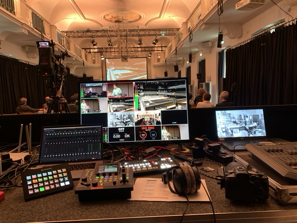 Multi-Kamera Livestream-Regie — Regiepult mit 3 Monitoren, voller Saal dahinter Karlsruhe